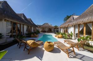 a resort patio with chairs and a swimming pool at Aloha Boutique Uluwatu in Uluwatu