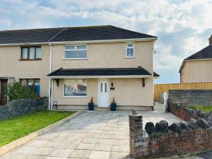 ein Haus mit einer Auffahrt davor in der Unterkunft Home with Ocean View - Contractors and Families in Port Talbot