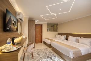 a hotel room with two beds and a desk at Secrets Of The Pyramids Hotel in Cairo