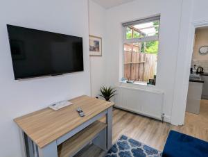 ウォルヴァーハンプトンにあるContractors 4BR Home, Newly Refurb, Nr Centreの壁に薄型テレビが取り付けられたリビングルーム