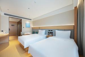 a hotel room with two beds and a bathroom at JI Hotel Beijing Fangzhuang Puhuangyu Subway Station in Beijing +24 photos