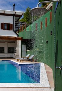 a swimming pool with a fountain in front of a house at Casa Varanda dos Pássaros in Morro de São Paulo