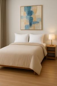 a bedroom with a white bed and a painting at Iris apartment in Perth