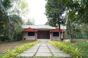 a small house with a walkway in front of it at Garcinia Villa in Sirsi