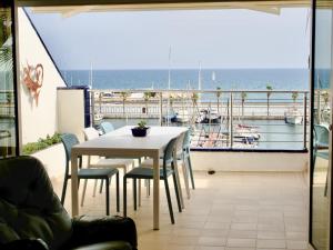 a table and chairs on a balcony with a view of the ocean at Stunning sea views over marina with swimming pool in Sitges