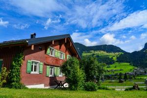 a house in a field with a view of a mountain at Villa Mondschein in Au im Bregenzerwald