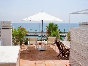 a patio with a table and chairs and an umbrella at Stunning sea views over marina with swimming pool in Sitges