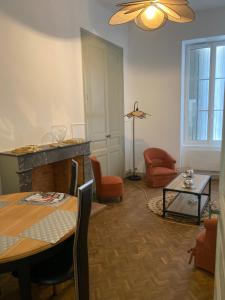 a living room with a table and a fireplace at Chambres centre ville Chateauneuf in Châteauneuf-sur-Charente