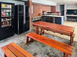 a kitchen with two wooden benches and a refrigerator at Beds Inn George in George