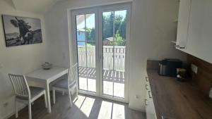 a kitchen with a table and chairs and a balcony at Ferienwohnung Peter in Steingaden