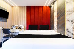 a bedroom with a large white bed and a red wall at Hotel O The Luxury Inn in Siliguri +21 photos
