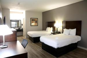 a hotel room with two beds and a desk at Americas Best Value Inn Monroe in Monroe +13 photos