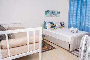 a bedroom with a white bed and a couch at Marve in Mtwapa