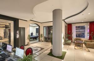 a lobby with a column and a table and chairs at Cloud Passion Hotel & Apartment in Ho Chi Minh City