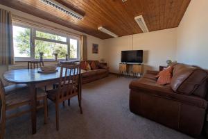 a living room with a table and a couch at Grapnells Lodge, Wallasea Island, Rochford, Essex in Rochford