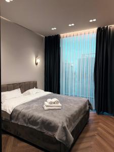 a bedroom with a bed with two towels on it at Urbanhome in Astana