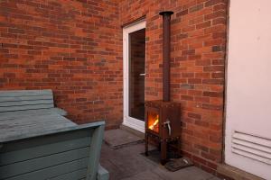 a brick wall with a wood stove next to a window at Grapnells Lodge, Wallasea Island, Rochford, Essex in Rochford