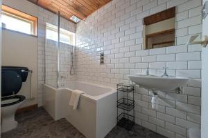 a bathroom with a sink and a tub and a toilet at Grapnells Lodge, Wallasea Island, Rochford, Essex in Rochford