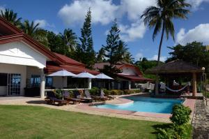 a resort with a swimming pool with chairs and umbrellas at Palmelía Beach Resort in Buruanga