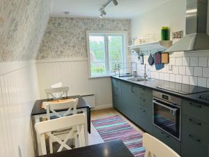 a kitchen with blue cabinets and a table and chairs at Söderåsens Skafferi - Logi in Ljungbyhed