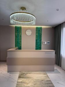 a lobby with a counter with green curtains and a chandelier at Bereke in Kostanay