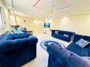 a living room with blue couches and a tv at villa Duplex in Sale