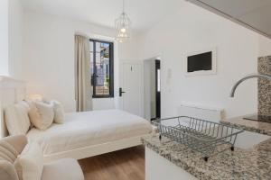a white room with a bed and a sink at Vila Francisco in Funchal