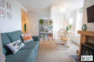 a living room with a blue couch and a table at The Bird's Nest - Free Parking! in Boscastle