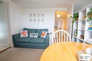 a living room with a blue couch and a table at The Bird's Nest - Free Parking! in Boscastle