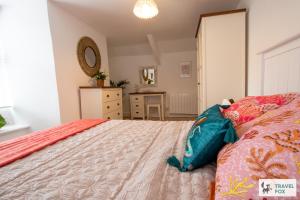 a bedroom with a bed and a dresser and a mirror at The Bird's Nest - Free Parking! in Boscastle