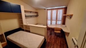 una pequeña habitación con una cama y una mesa en Villetta Gemma, en Lido di Camaiore