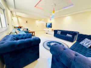 a living room with two blue couches and a table at Maison Duplex in Sale