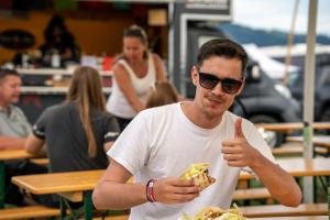 a man giving a thumbs up while eating a slice of pizza at Schitterhof CHALETS in Spielberg +22 photos