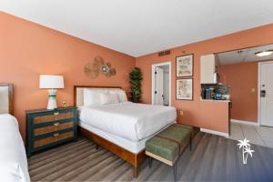 a bedroom with a large white bed and orange walls at Boho Chic Garden Condo 7 Min to Universal Parks in Orlando