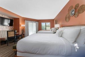 a bedroom with a large white bed and a desk at Boho Chic Garden Condo 7 Min to Universal Parks in Orlando