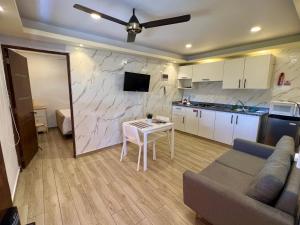 a living room with a couch and a table and a kitchen at Studios Don Bosco in Santo Domingo
