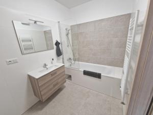 Un baño blanco con lavabo y ducha. en VIA Apartmany, en Trenčín 17 fotos más