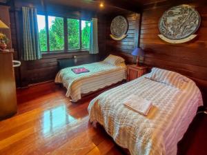 due letti in una stanza con pareti in legno di Ocean View Garden Retreat by the Golf Course a Santa Cruz