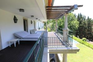 a porch with a blue couch on a deck at Celebration or Event & Stay at Casa dos Macieis, Private Pool, Camino Santiago direct access & Optional Agritourism in Facha