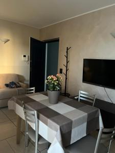 a living room with a table and a tv at Tomati's House in Alba