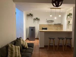a living room with a couch and a kitchen at Luum Suites Taxco in Taxco de Alarcón