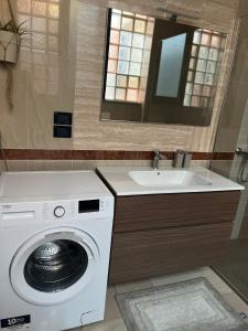 a bathroom with a washing machine and a sink at Tomati's House in Alba