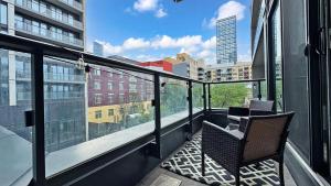 a balcony with two chairs and a view of a city at Cozy 1BR Condo in Core Toronto in Toronto