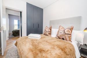 Un dormitorio con una cama grande con una manta marrón. en Paarl 225 - Lux Modern 2 Bedroom Apartment with Parking, en Paarl