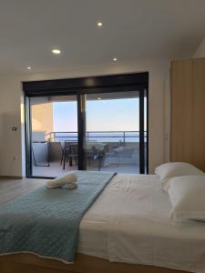 a bedroom with a bed with a view of the ocean at Apartment Hortenzija in Baška Voda