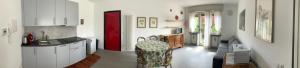 a kitchen with white cabinets and a red door at Casa Giorgio in Malnate