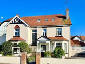 a large white house with a red roof at Cleave Court Guest House in Llandudno