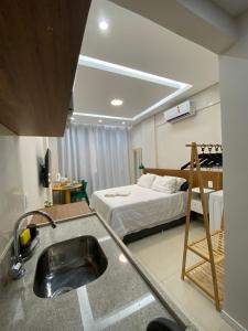 - une cuisine avec évier et un lit dans une chambre dans l'établissement Lindo e luxuoso apto no coração de Copacabana, à Rio de Janeiro
