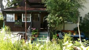 a small house with a porch and a garden at Omas Häuschen am See in Dießen am Ammersee