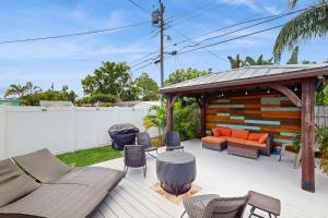 een terras met een prieel, stoelen en een bank bij Bermuda Oasis in Seminole